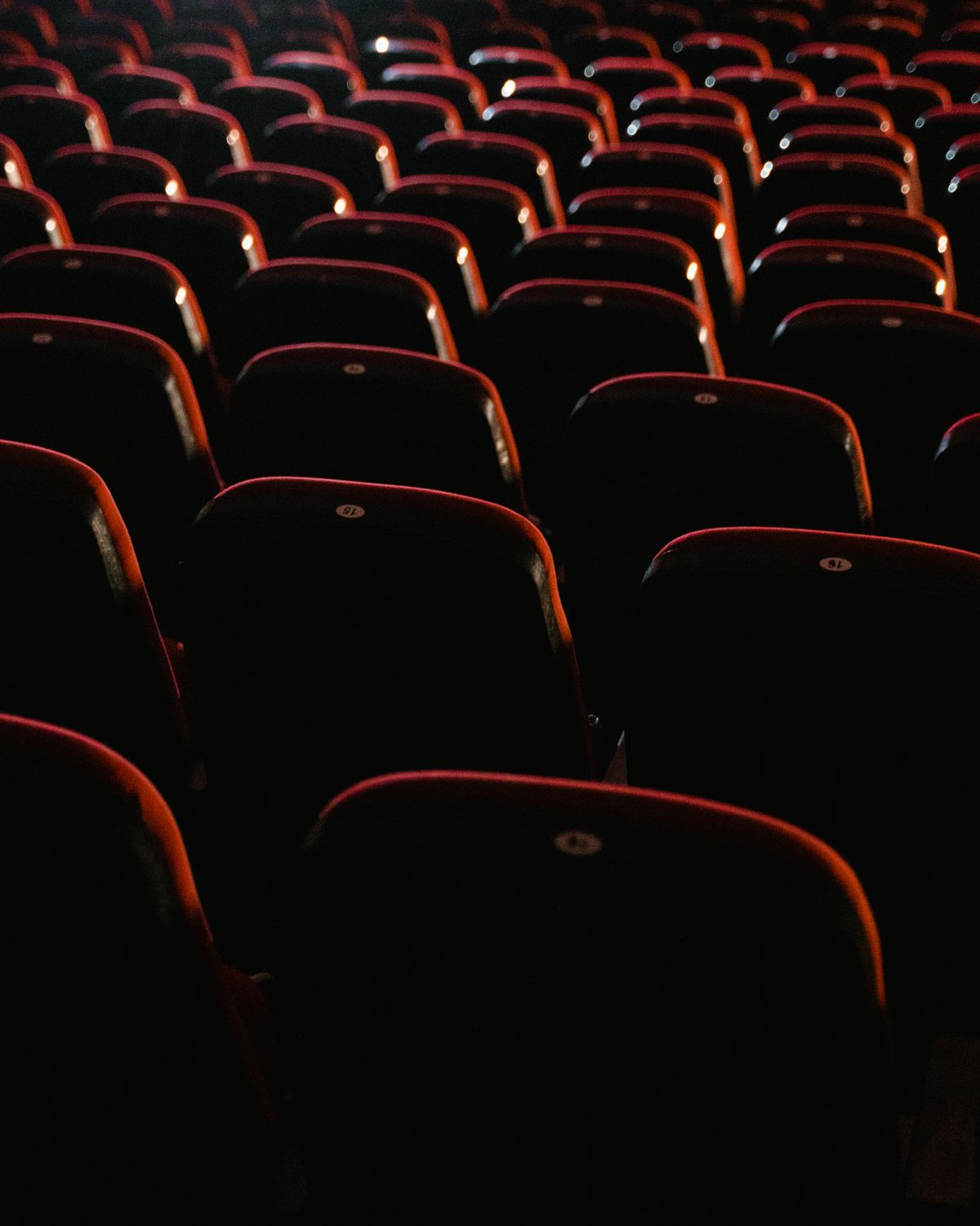 Butacas rojas de una sala de cine a oscuras